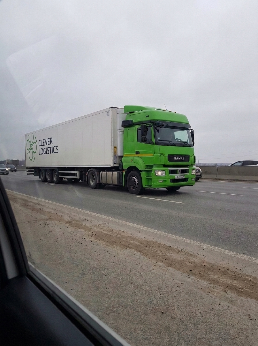 Грузовой автомобиль движется по трассе в процессе транспортировки.