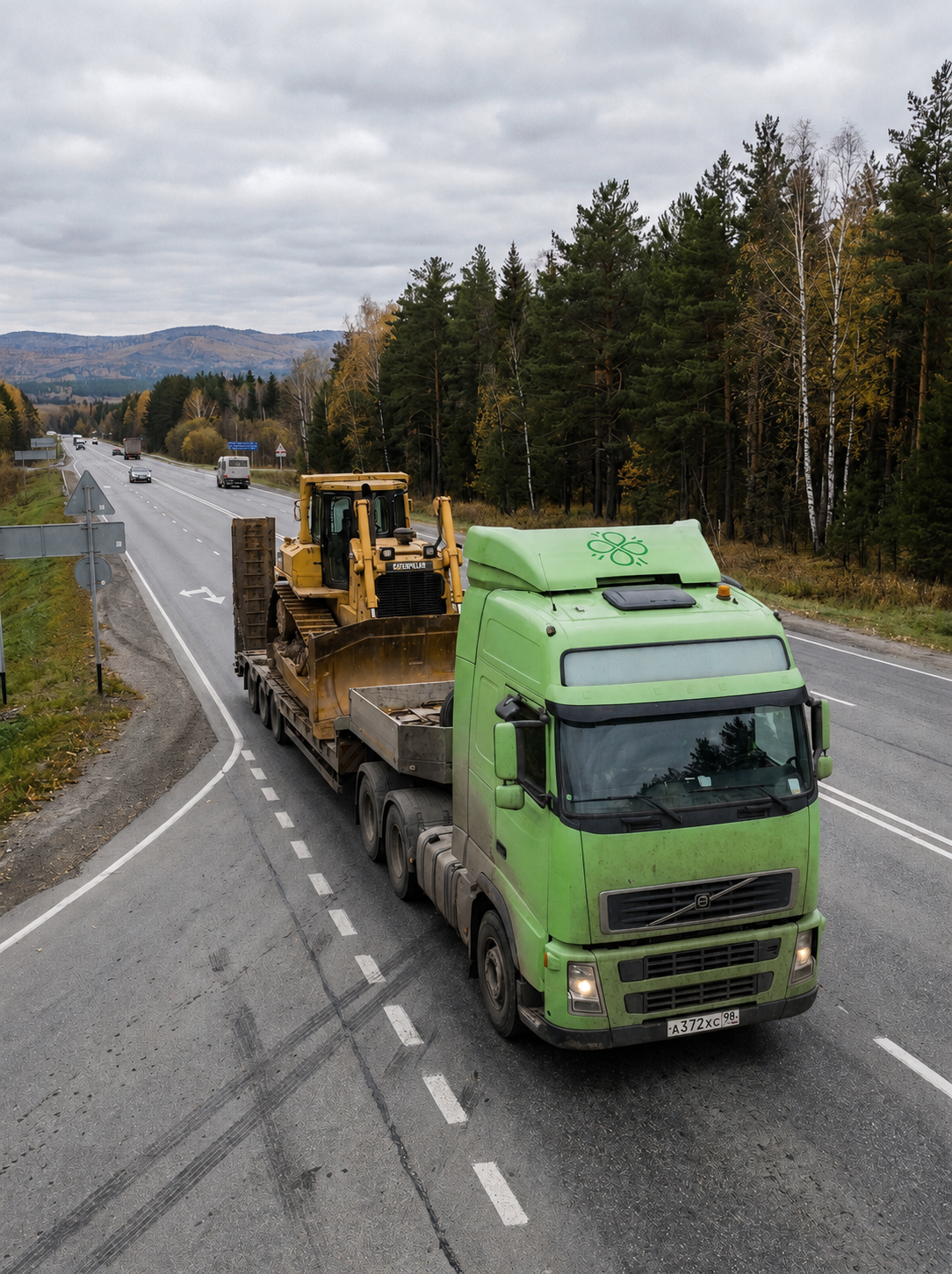 Зеленый грузовик Scania компании Clever Logistics на территории современного складского комплекса с солнечными батареями.
